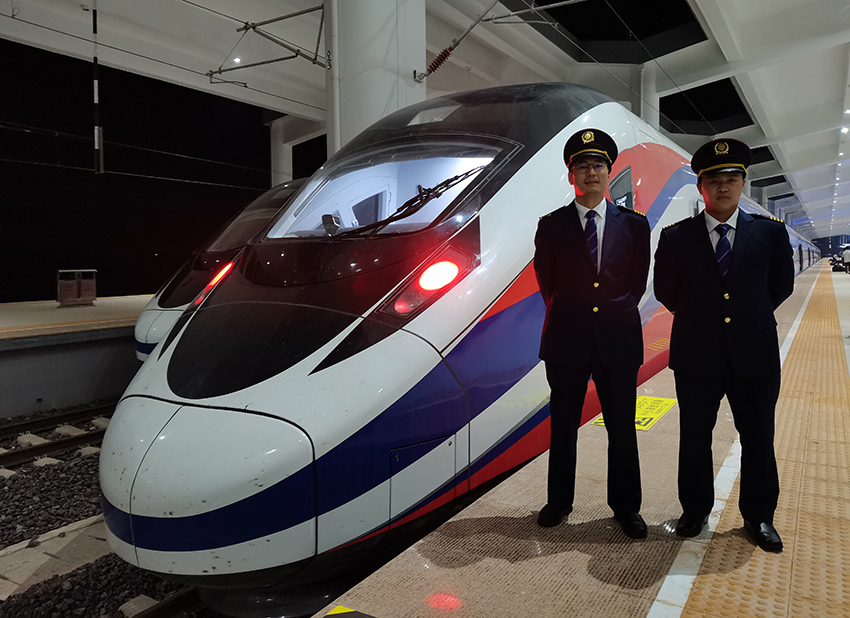 劉銀能（右一）與中國師父鄔俊鴻在動(dòng)車組前合影。受訪者供圖
